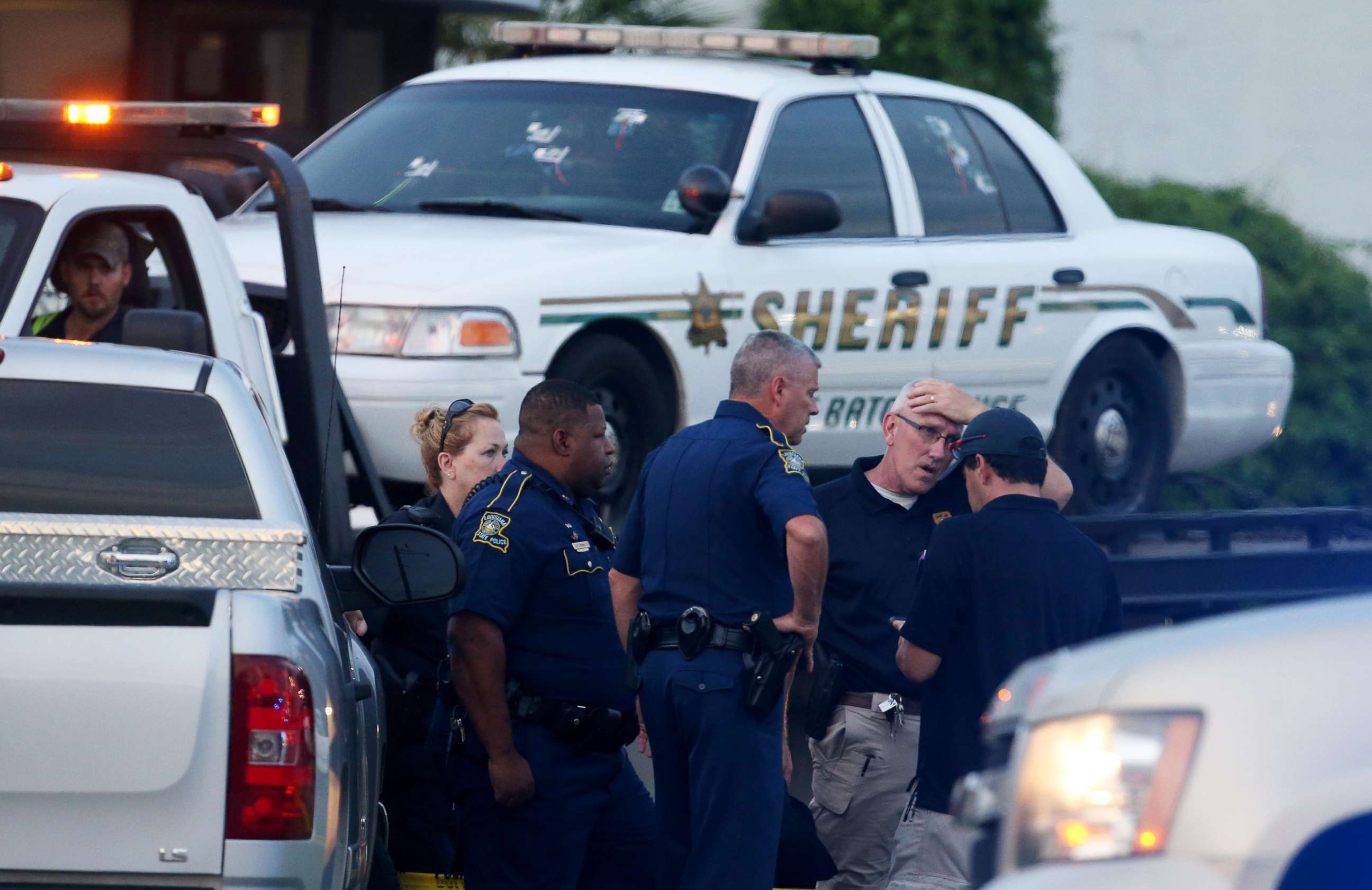 PHOTO: Police officers stand in front of an East Baton Rouge police car with bullet holes as it's towed away from the scene where police officers were killed, July 17, 2016, in Baton Rouge, Louisiana.