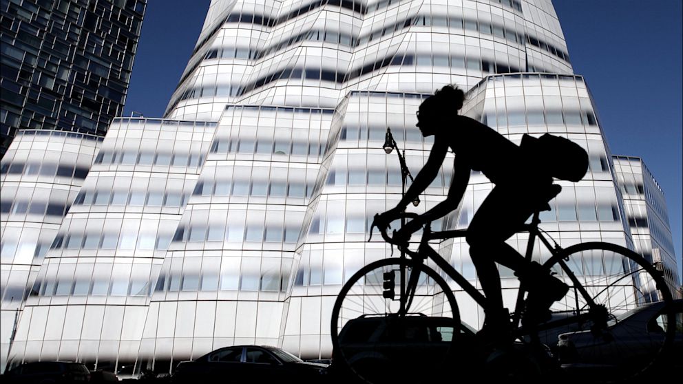 Silhouette of a cyclist who passes the InterActiveCorp building in New York, May 14, 2013.