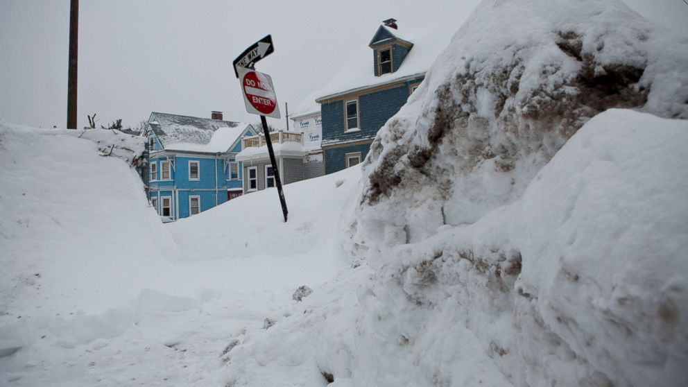 Snow banks from prior snowstorms rise above street signs on the corner of a residential street on Feb.9, 2015, in the Dorchester neighborhood of Boston, Mass. 