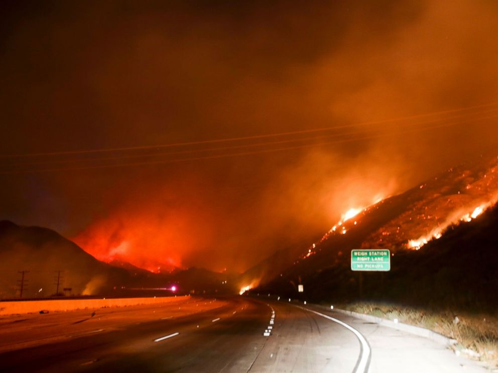 PHOTO: Flames burn next to the Interstate 15 as the Blue Cut wildfire rages near Cajon Pass, north of San Bernardino, California, Aug. 16, 2016.