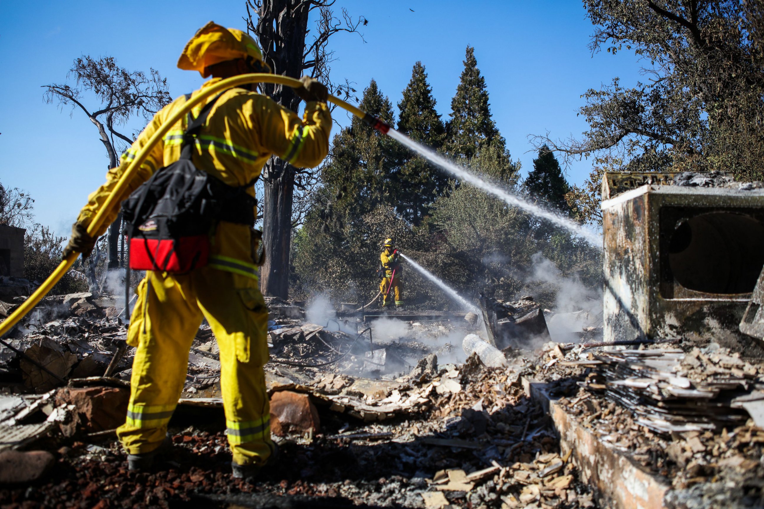 PHOTO: A firefighter works to contain embers on the remains of a house destroyed in the Clayton Fire are seen in Lower Lake, California, Aug. 15, 2016.