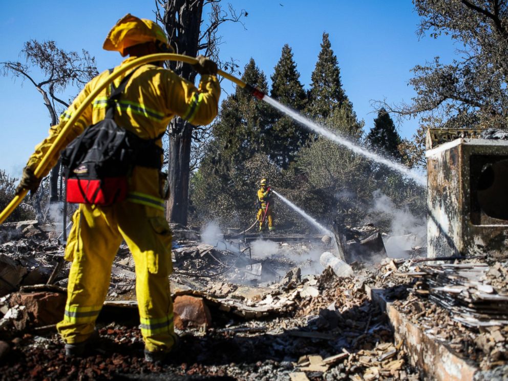 PHOTO: A firefighter works to contain embers on the remains of a house destroyed in the Clayton Fire are seen in Lower Lake, California, Aug. 15, 2016.