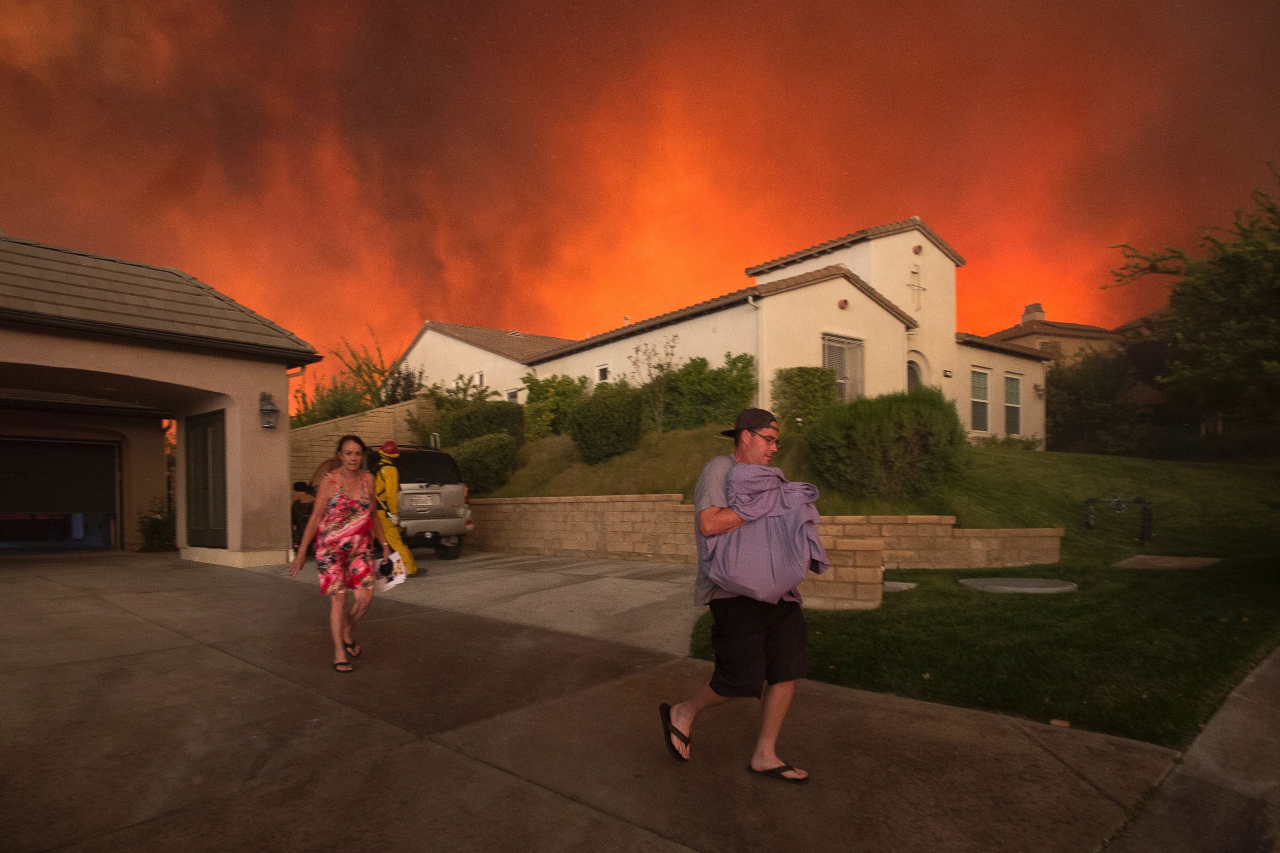 PHOTO: Residents flee their home as flames from the Sand Fire close in, July 23 2016 near Santa Clarita, California. 
