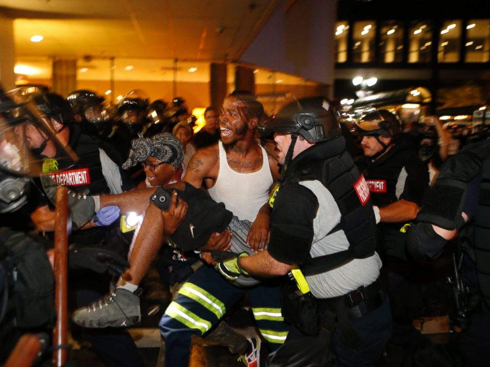 PHOTO: Police and protesters carry a seriously wounded protester into the parking area of the the Omni Hotel during a march to protest the death of Keith Scott Sept. 21, 2016 in Carolina.