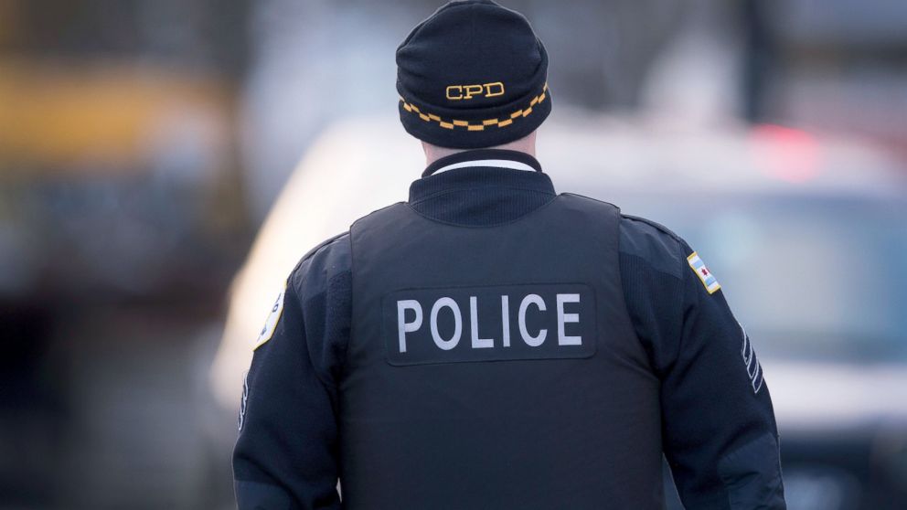A Chicago police officer guards the perimeter of a crime scene where six people were found slain inside a home on the city's Southwest Side, Feb. 4, 2016, in Chicago.