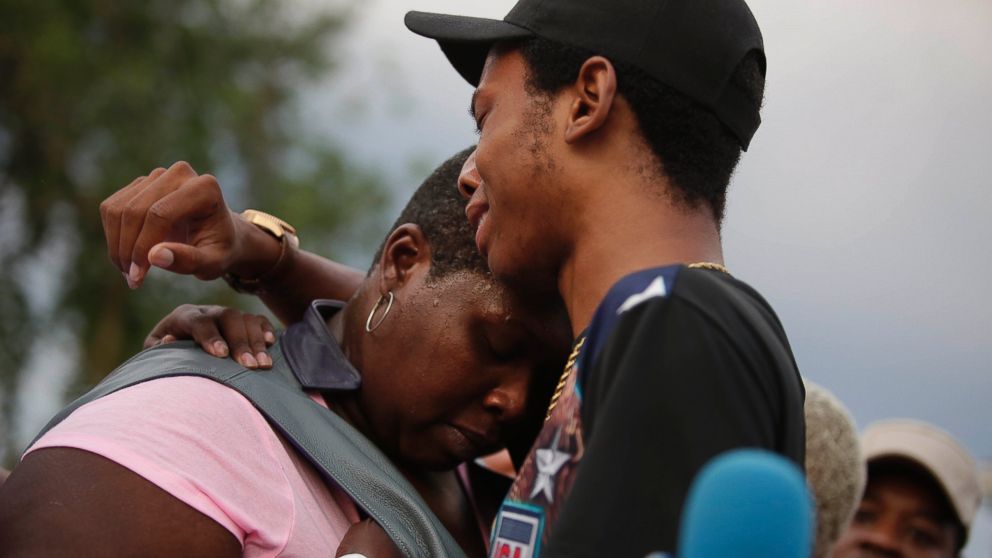 Activist Lamon Reccord, center, consoles Sheila Jones, center, mother of Africa Bass during a vigil for Bass, who was killed as she walked through her apartment complex July 27, 2016, in Chicago. 