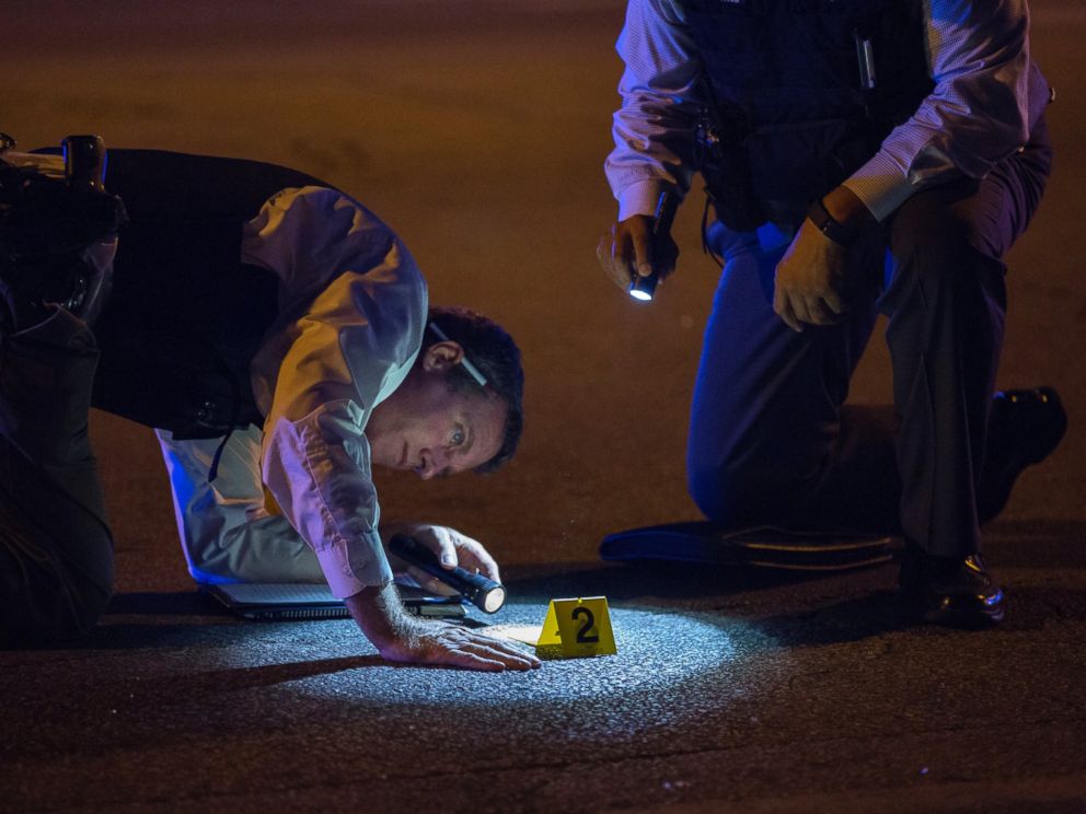 PHOTO: Members of the Chicago Police Department look at an evidence marker at the scene of a shooting in the 3100 block of West 83rd Place, Aug. 8, 2016, in the Ashburn neighborhood of Chicago.