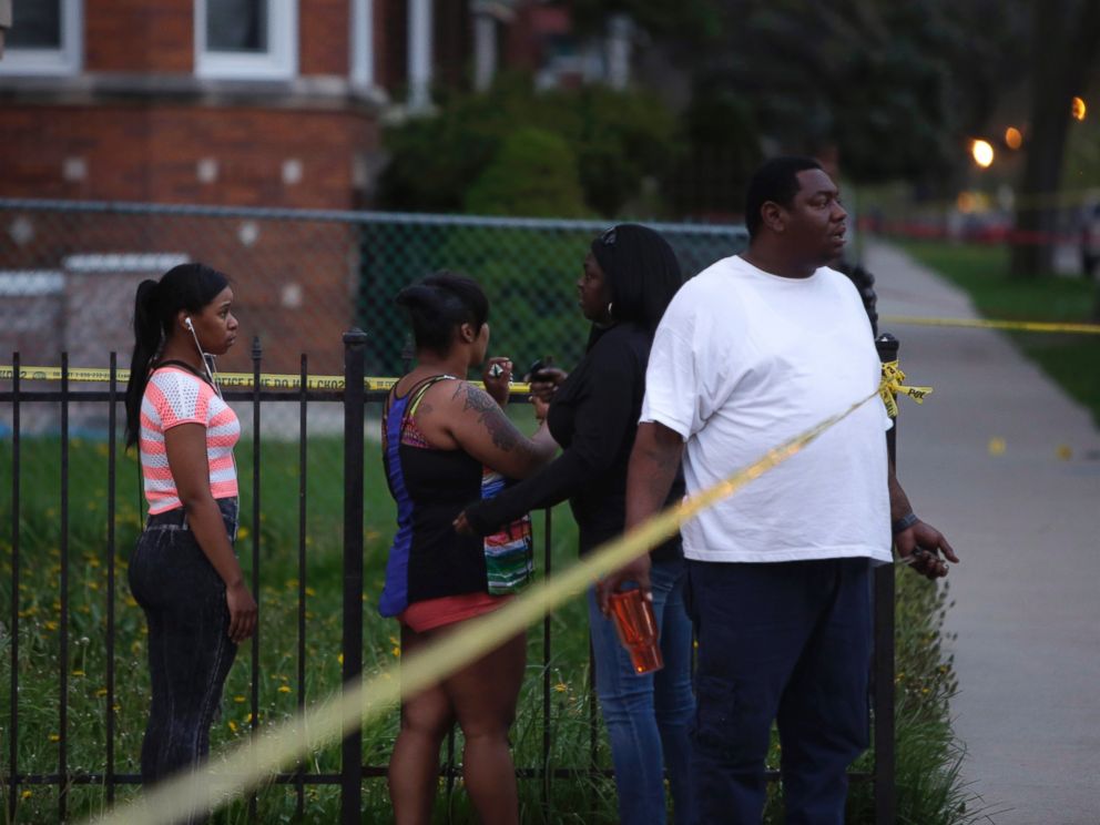 PHOTO: People watch as Chicago Police officers and evidence technicians investigate the scene where a 16-year-old boy was shot in the head and killed and another 18-year-old man was shot and wounded on April 25, 2016, in Chicago.