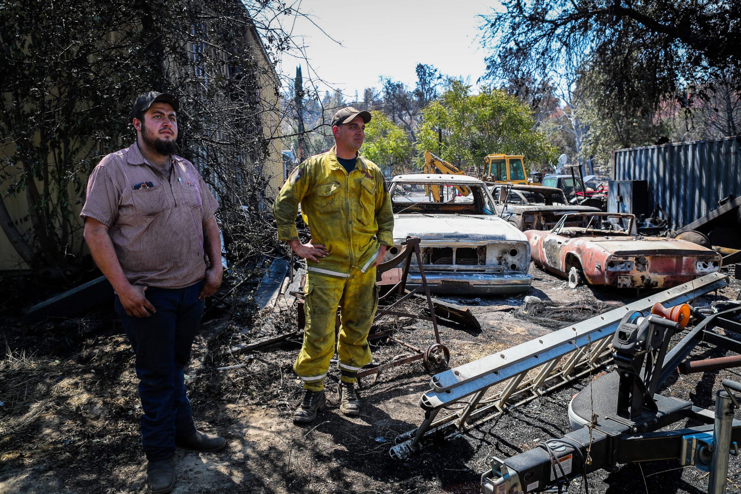 PHOTO: Residents Wade Holley, left, and Mike Boyce look over the damage to their cars in the Clayton Fire at the Clearlake machine shop in Lower Lake, California, Aug. 16, 2016.