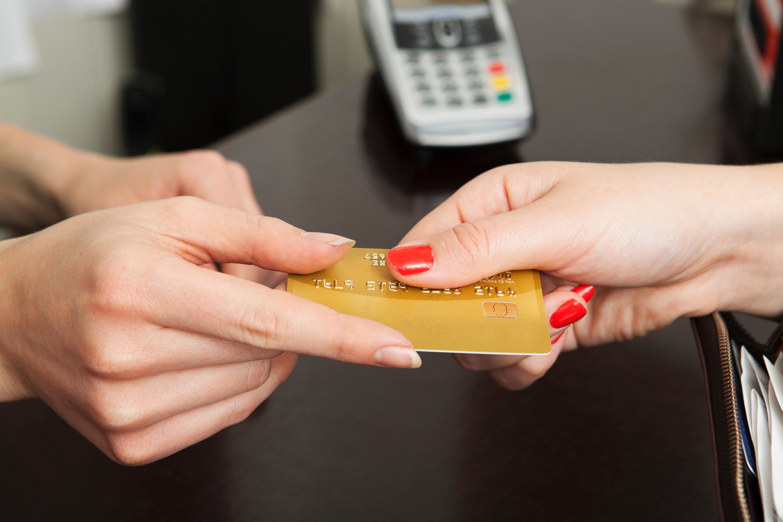 PHOTO: A woman hands over a credit card for payment.