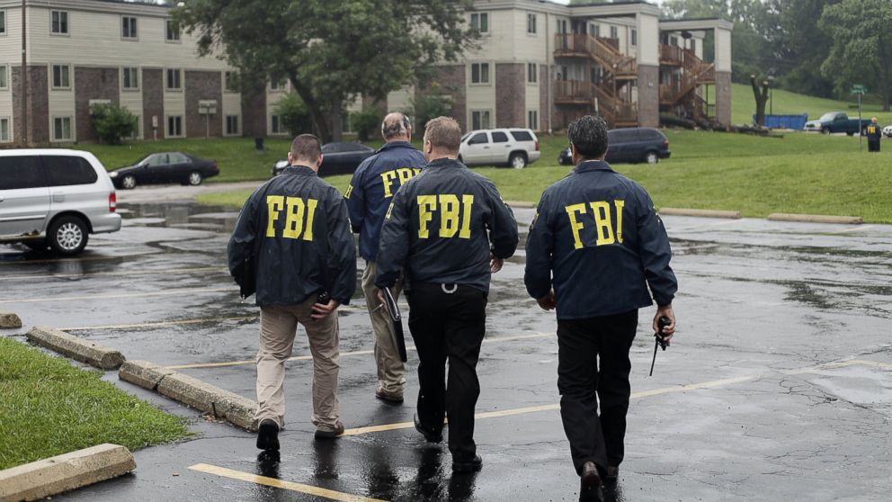 FBI Agents are seen in this Aug. 16, 2014  file photo investigating  the shooting death of 18-year-old Michael Brown at the location where he was killed on Canfield Drive in Ferguson, Mo.