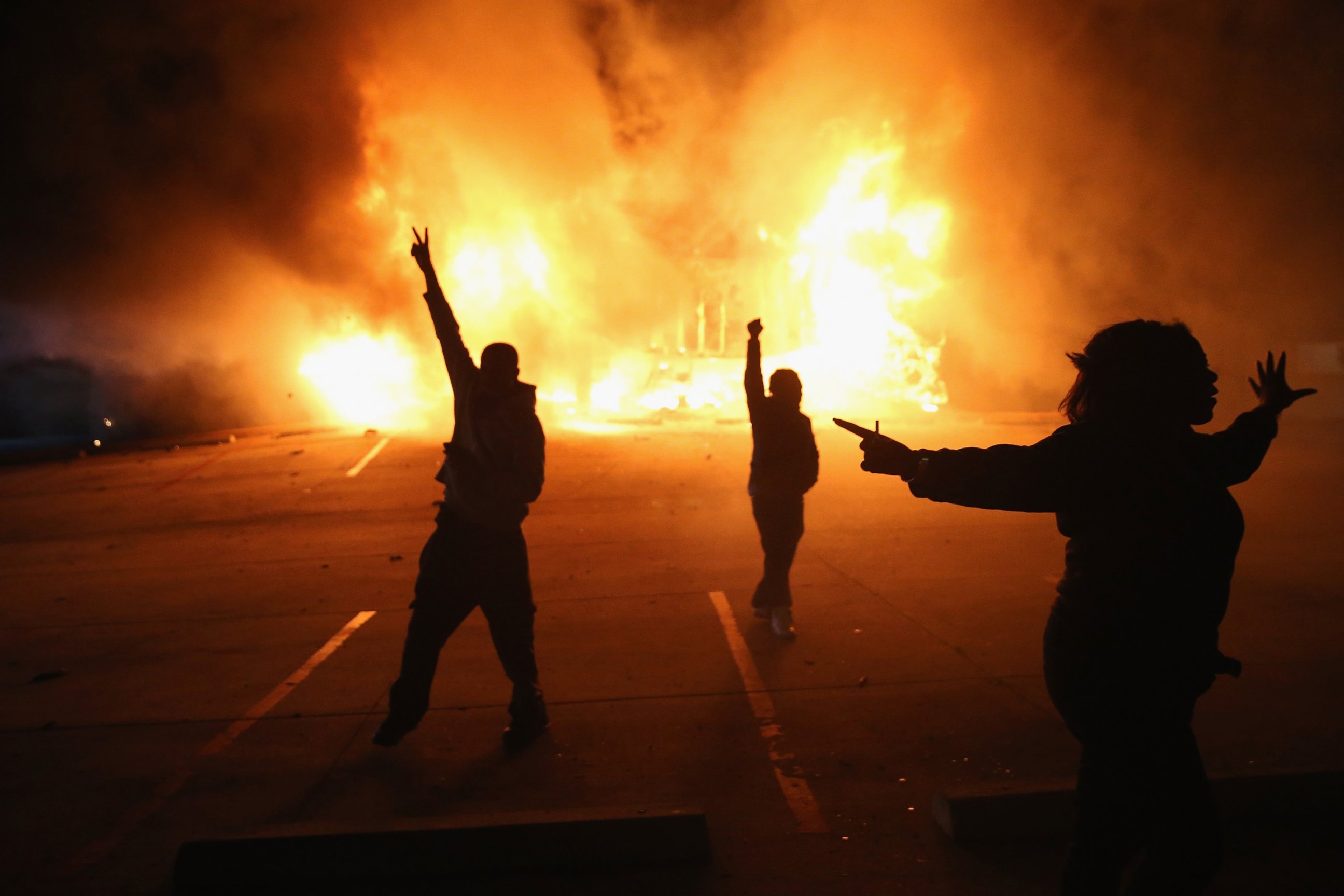 PHOTO: Demonstrators celebrate as a business burns after it was set on fire during riots following the grand jury announcement in the Michael Brown case, Nov. 24, 2014 in Ferguson, Missouri. 