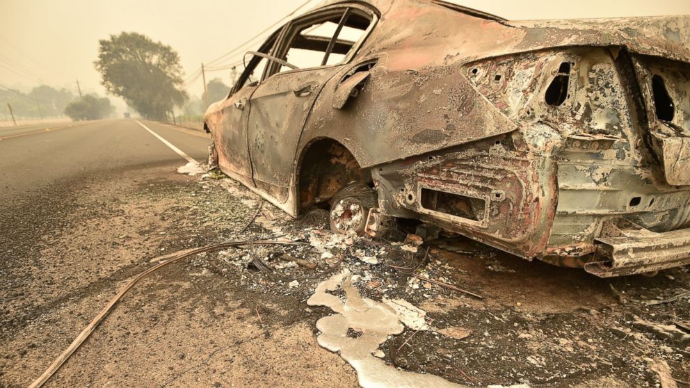 PHOTO: Melted metal flows from a burned out car abandoned on a highway near the Valley fire in Middletown, Calif., Sept. 13, 2015. 