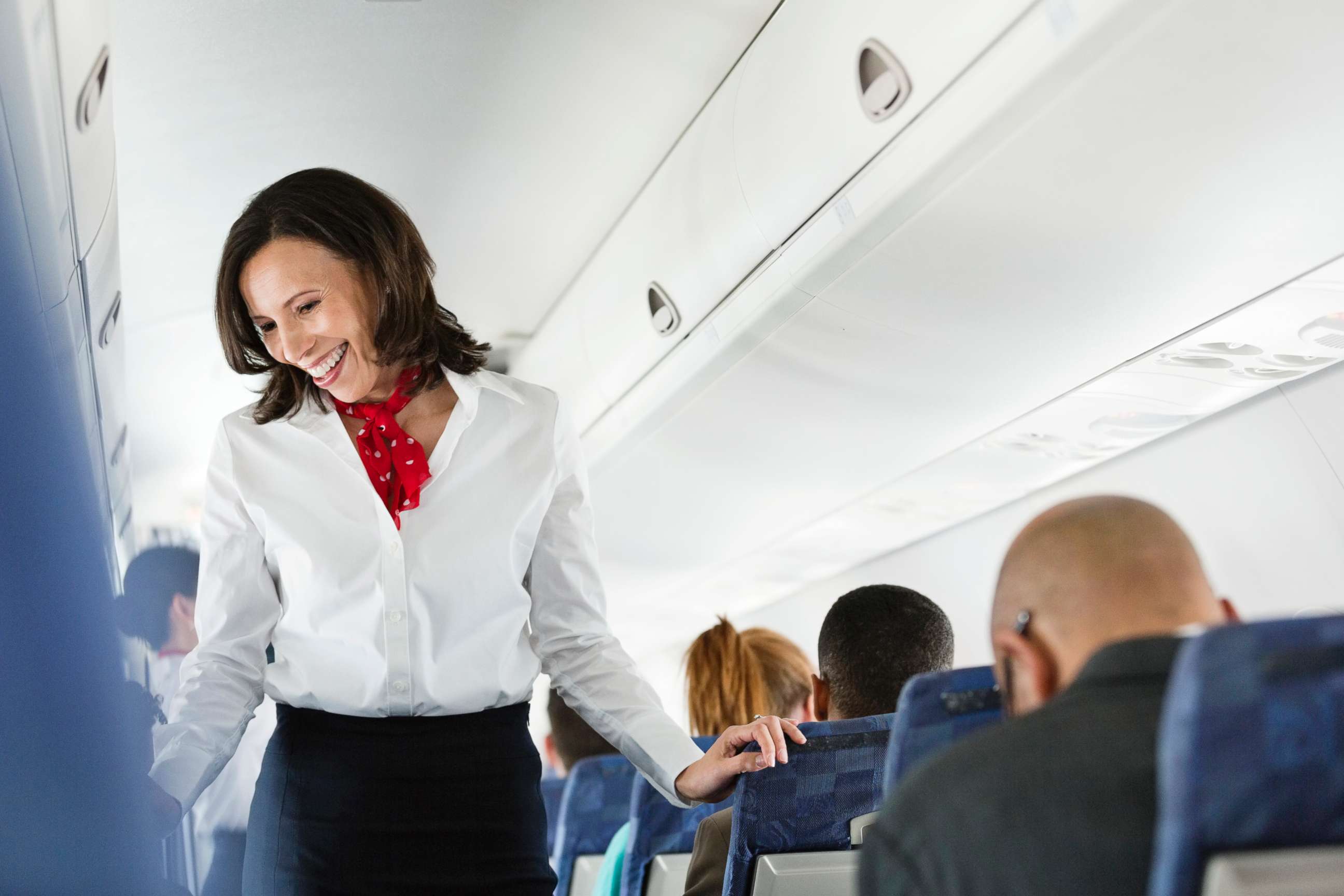 PHOTO: A flight attendant helps a passenger.