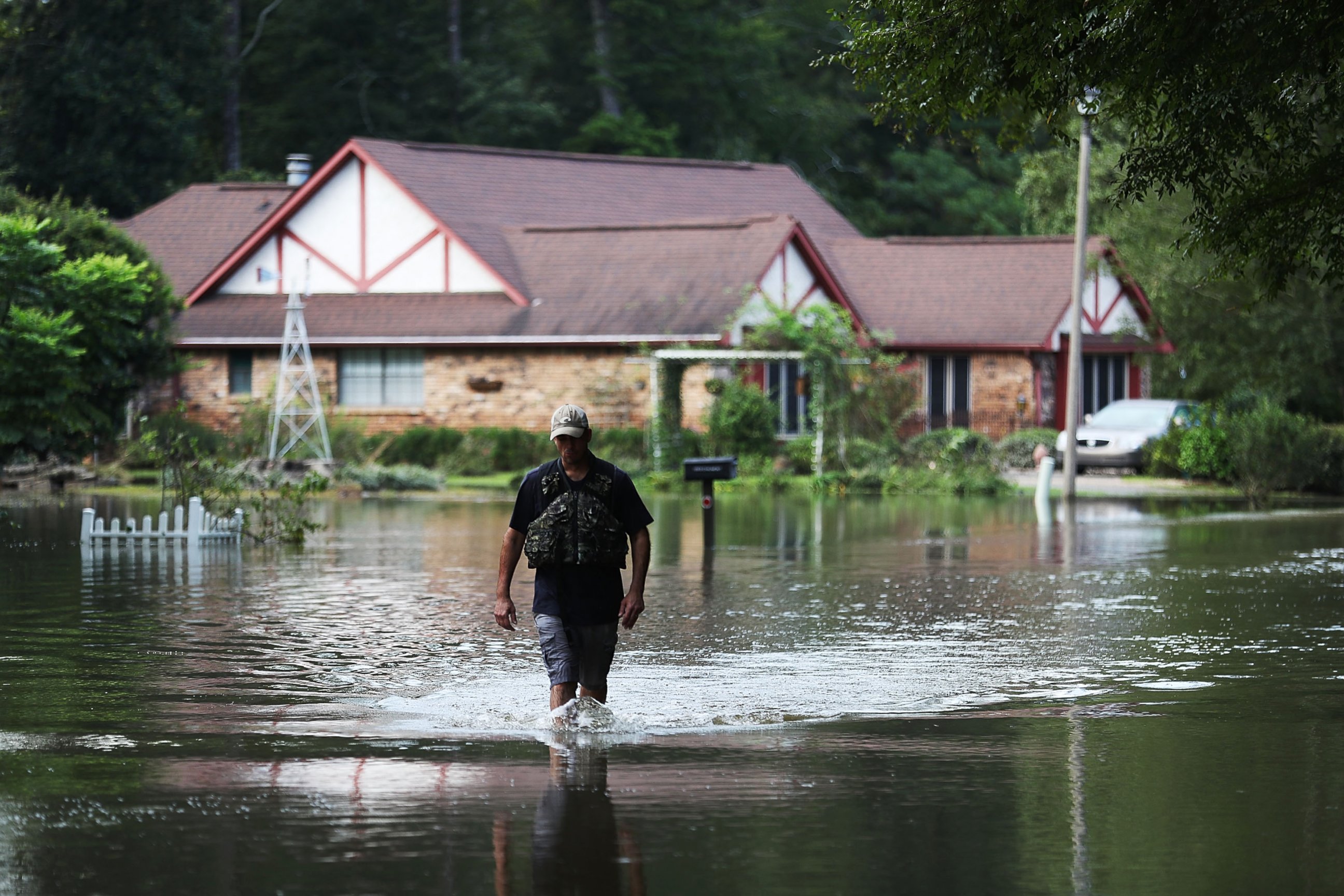 PHOTO: Ryan Evans walks along a flooded road, Aug. 15, 2016, in Baton Rouge, Louisiana.
