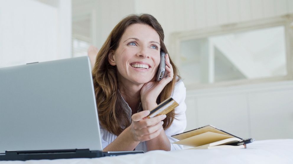 A woman looks happy while making a purchase over the phone in this undated file photo.