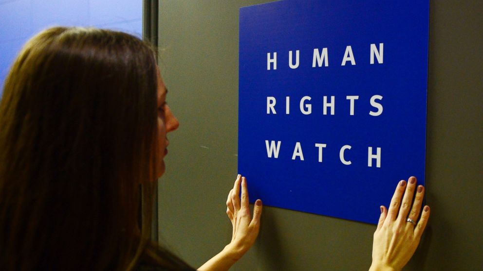 A woman puts a logo of US-based rights group Human Rights Watch on the door as she prepares the room before their press conference to release their annual World report in this Jan 21, 2014 file photo in Berlin.