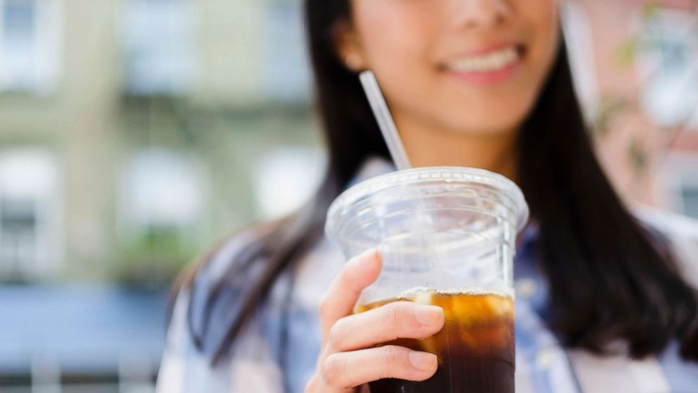  foto:en kvinde drikker en iskaffe i dette udaterede stockfoto.