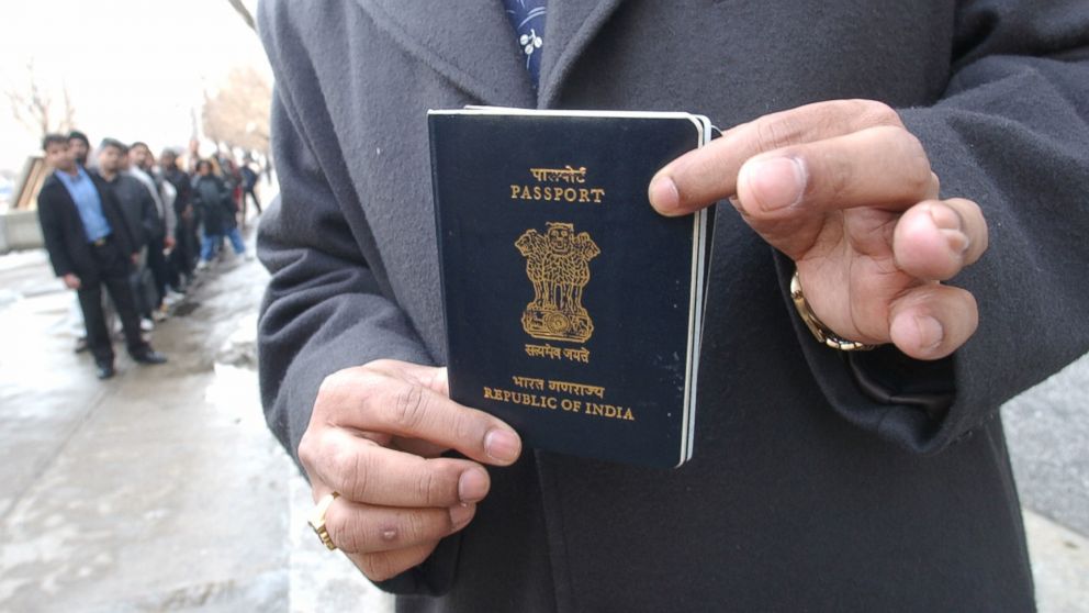 PHOTO: Yog Gorur picks up his India passport from the US CONSULATE in Toronto while other people lineup in front of U.S. CONSULATE to apply or pick up visa applications. 