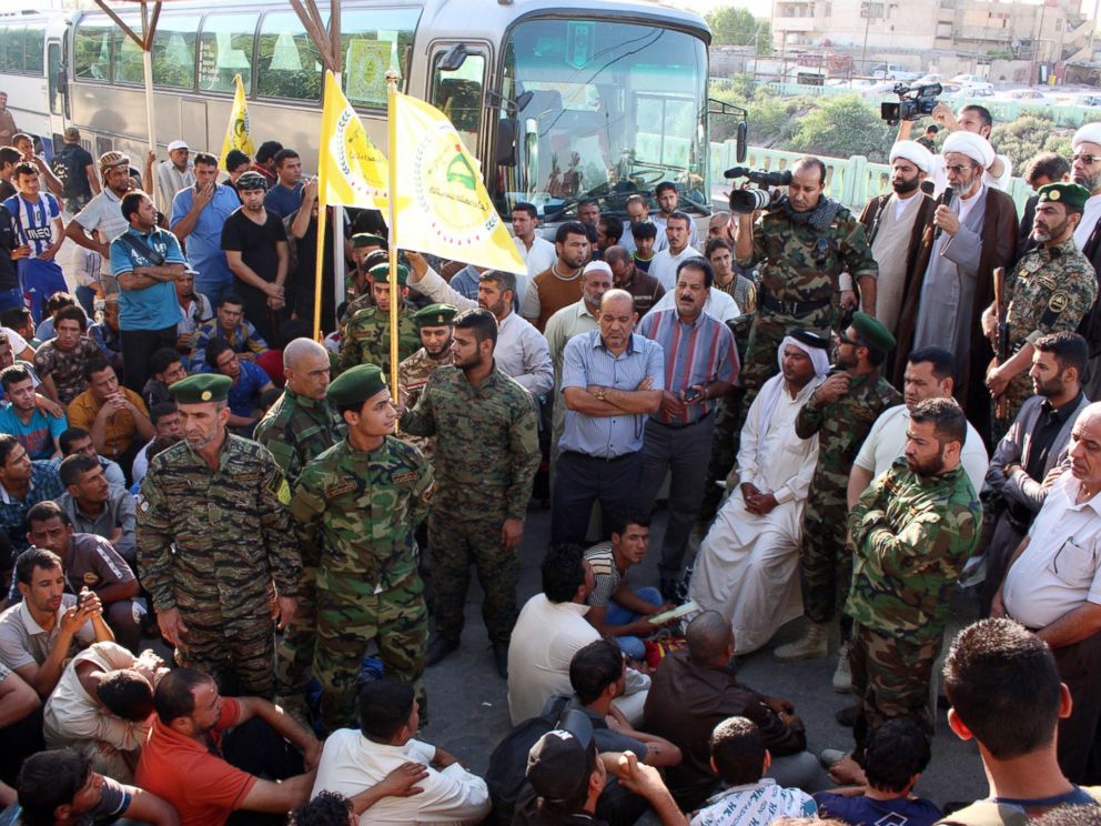PHOTO: Iraqi civilians volunteering to fight a militant offensive gather themselves together among members of security forces on June 15, 2014, in the southern port city of Basra before going to Iraqi second city Mosul.