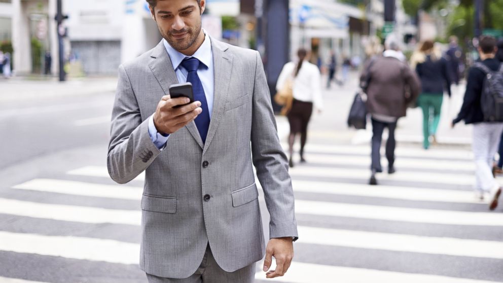 A young man is shown texting and walking in this undated stock photo.