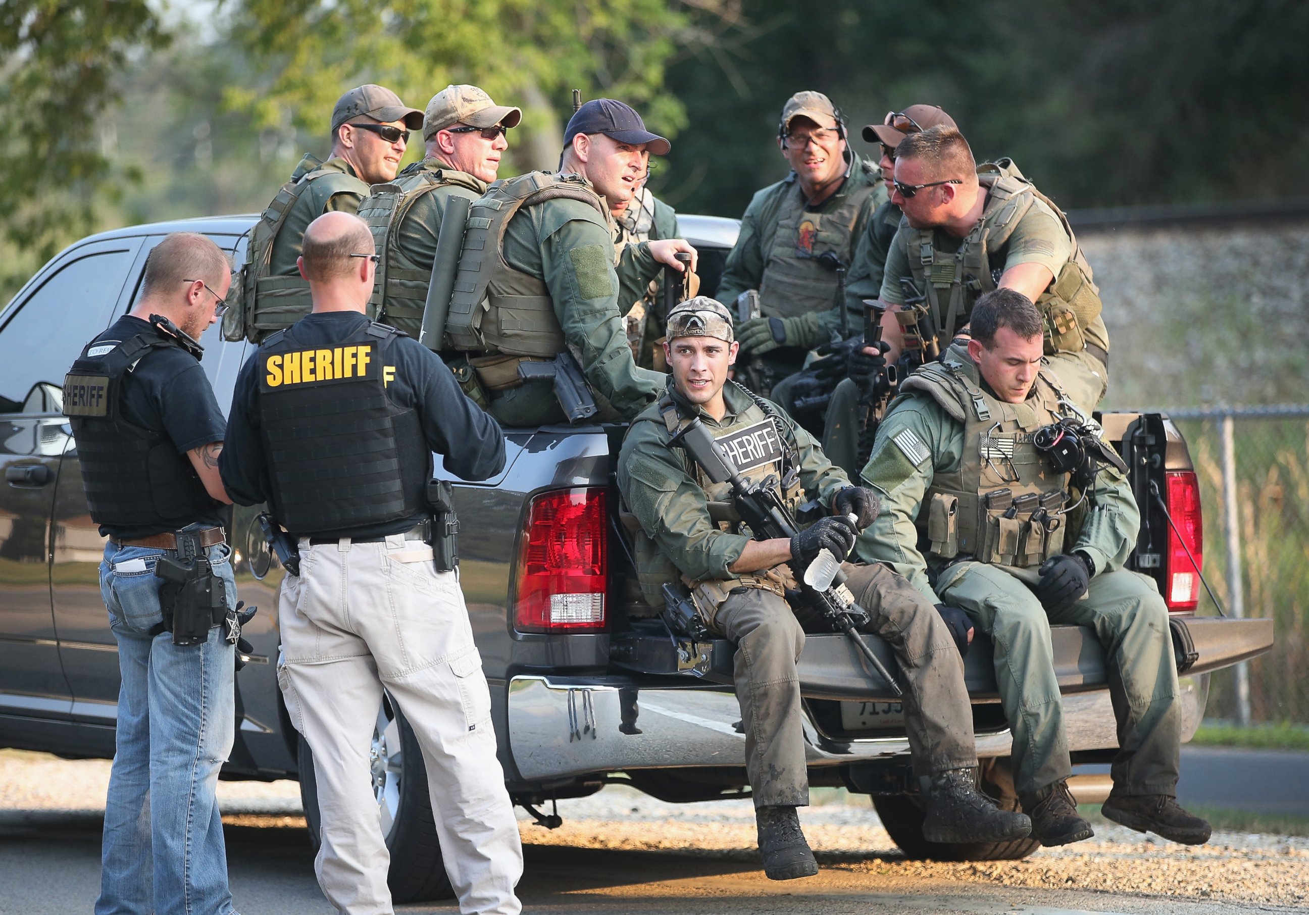 PHOTO: Police officers get a break after coming off a search mission as temperatures exceeded 90 degrees during a manhunt for three suspects in the murder of a Fox Lake Police officer, Sept. 1, 2015, in Fox Lake, Ill.  