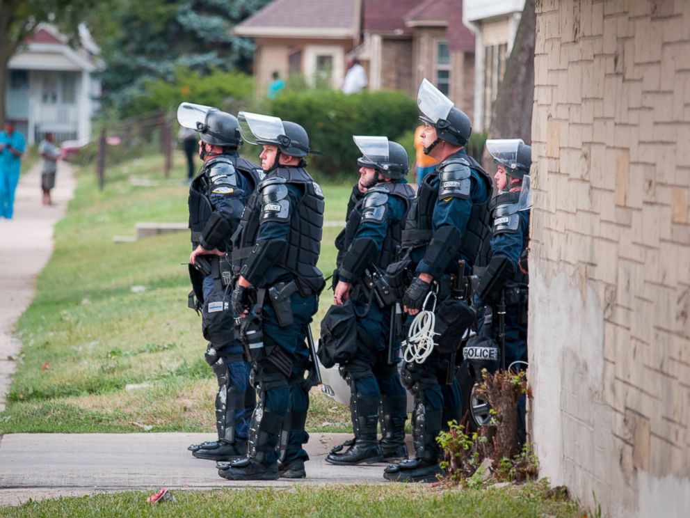 PHOTO: Police in riot gear wait in an alley after a second night of clashes between protestors and police, Aug. 15, 2016, in Milwaukee, Wisconsin.