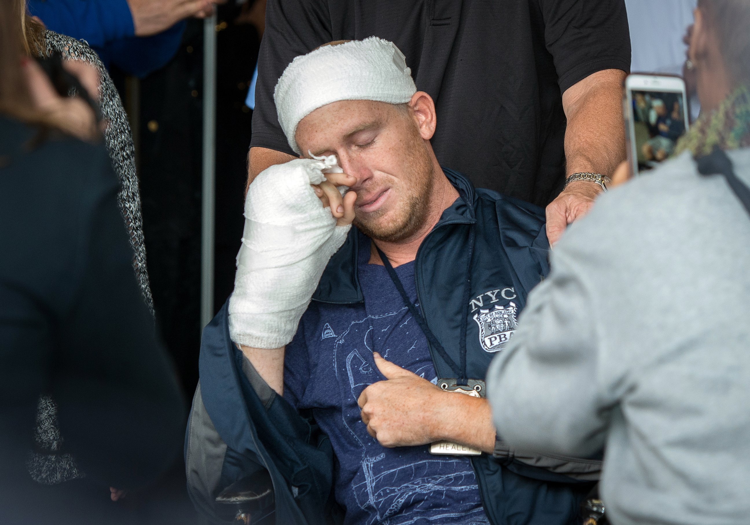 PHOTO: NYPD Police Officer Kenneth Healey, 25, who was attack with a hatchet by Zale Thompson, wipes his tears as he was released from Jamaica Hospital Medical Center located at  8900 Van Wyck Expressway in Queens, Oct. 29, 2014.