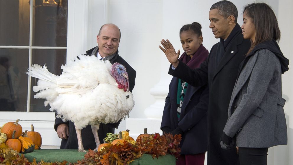 President Barack Obama pardons the National Thanksgiving Turkey, "Popcorn," with his daughters Sasha and Malia during an event at the White House in Washington, Nov. 27, 2013.