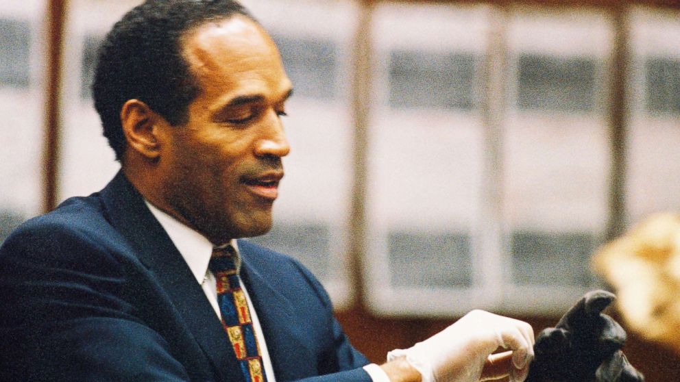 PHOTO: O.J. Simpson tries on a leather glove allegedly used in the murders of Nicole Brown Simpson and Ronald Goldman during testimony in Simpson's murder trial June 15, 1995 in Los Angeles.