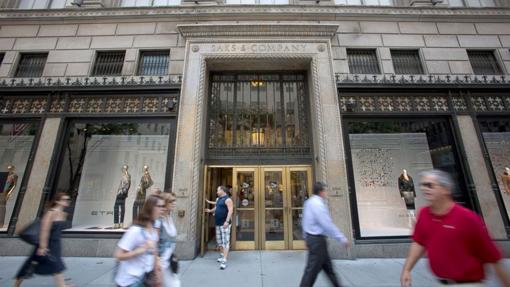 PHOTO: Pedestrians pass in front of Saks Fifth Avenue in New York, July 29, 2013. 
