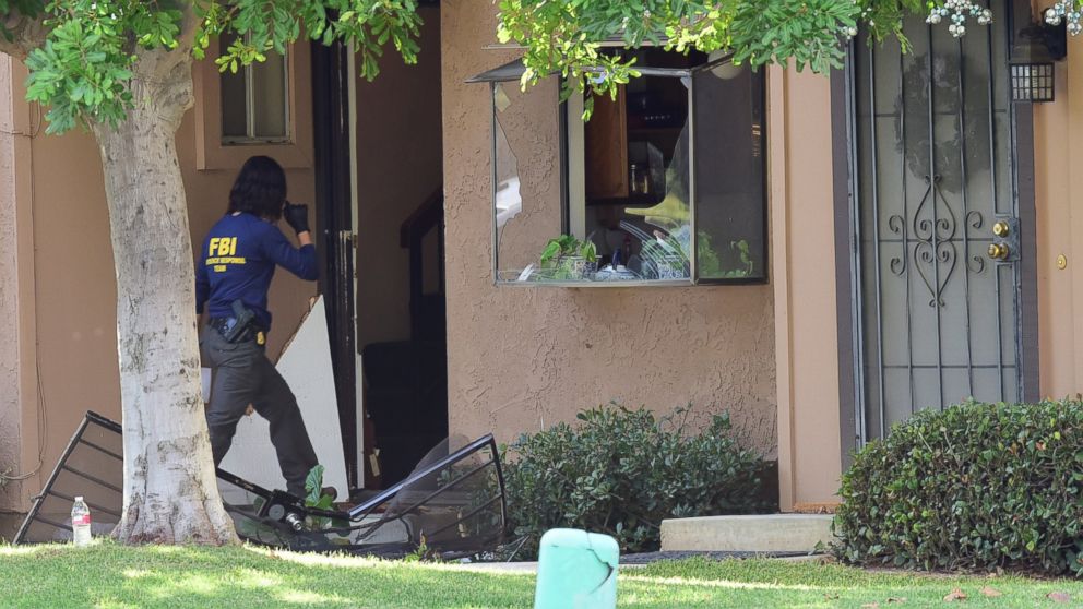 PHOTO: An member of an FBI evidence response team walks over a destroyed door to enter a townhome in Redlands, Calif., Dec. 3, 2015, linked to the Dec. 2 shooting rampage in San Bernardino. 