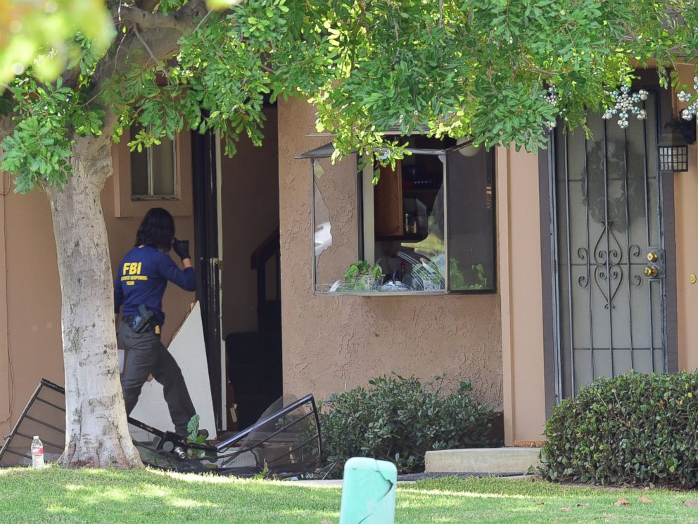 PHOTO: An member of an FBI evidence response team walks over a destroyed door to enter a townhome in Redlands, Calif., Dec. 3, 2015, linked to the Dec. 2 shooting rampage in San Bernardino.