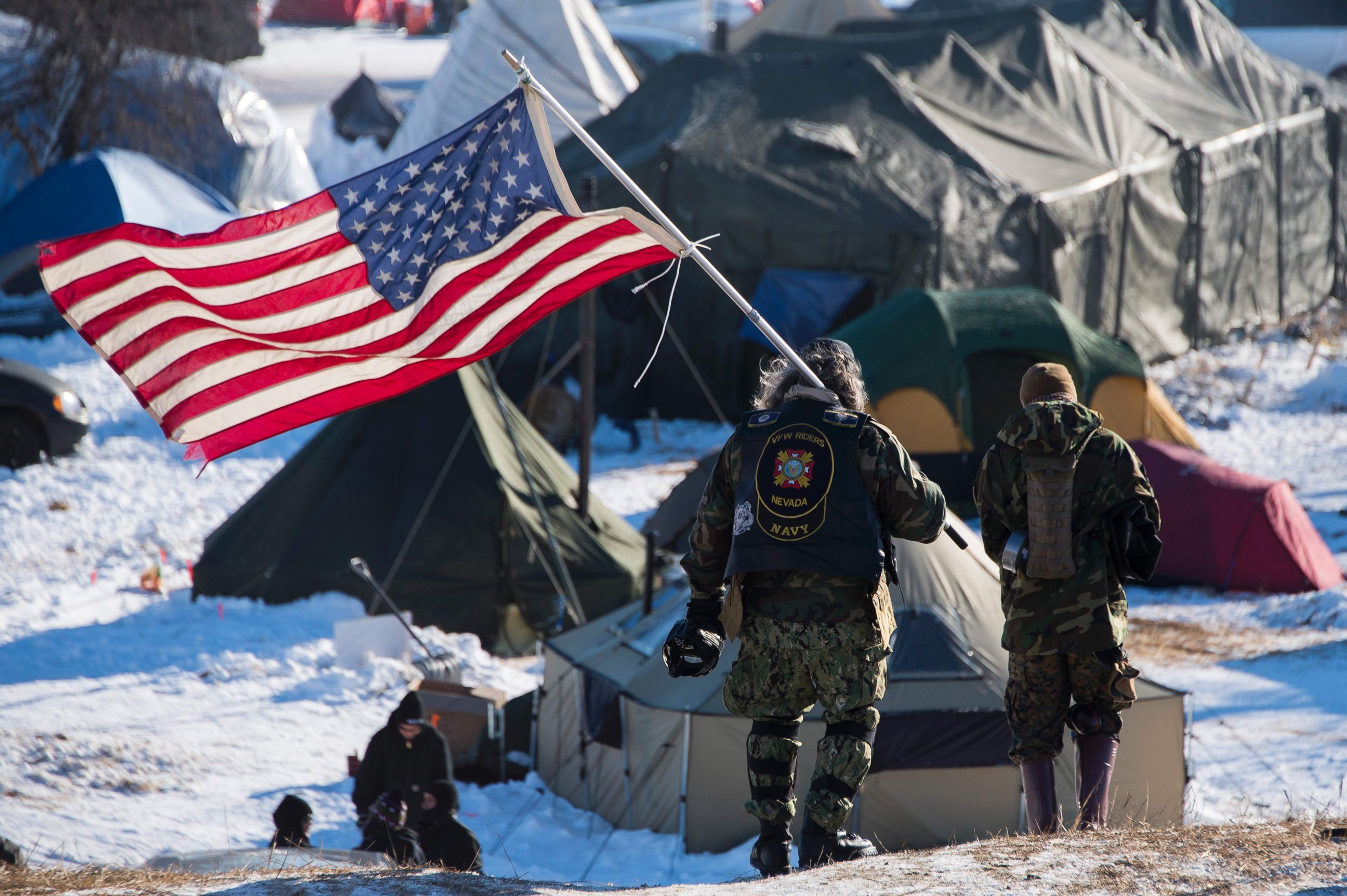 PHOTO: Rob McHaney, a veteran, holds a flag as he leads a group of veteran activists back from a police barricade on a bridge near Oceti Sakowin Camp on the edge of the Standing Rock Sioux Reservation, Dec. 4, 2016 outside Cannon Ball, North Dakota.