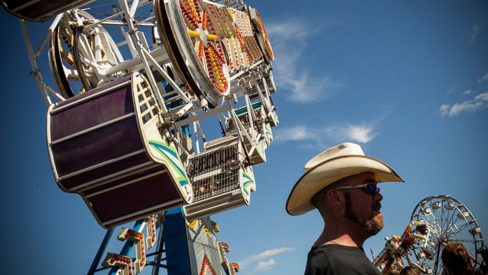 PHOTO: A man stands beneath a ride at the North Dakota state fair, July 27, 2013, in Williston, North Dakota.