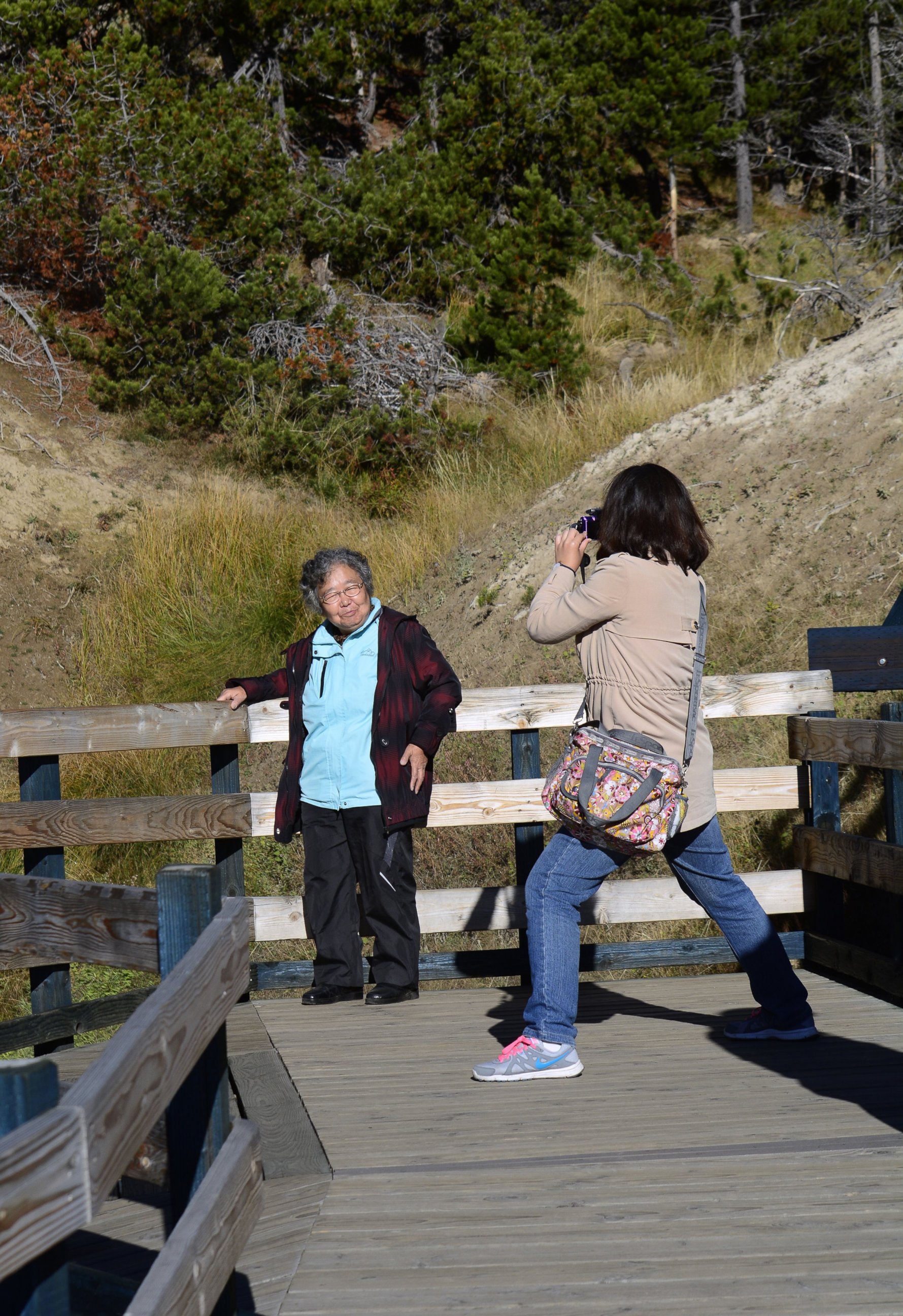 PHOTO: Tourists from China take souvenir photographs on a boardwalk leading to Dragon's Mount Spring, a popular geothermal attraction in Yellowstone National Park in Wyoming on Sept. 25, 2014. 