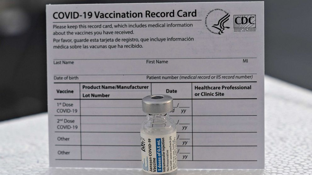 PHOTO: A COVID-19 J&J vaccine and a vaccination record card.