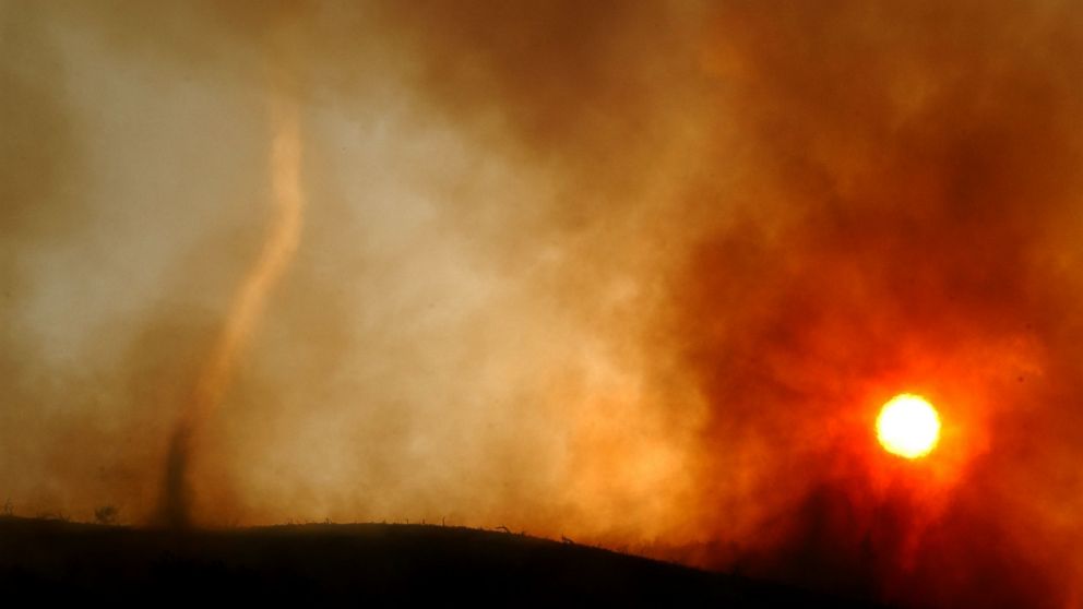 PHOTO: A wildfire-induced tornado of hot ash dances across a ridgetop as the sun sets May 13, 2002 near Rancho Santa Margarita, CA. 