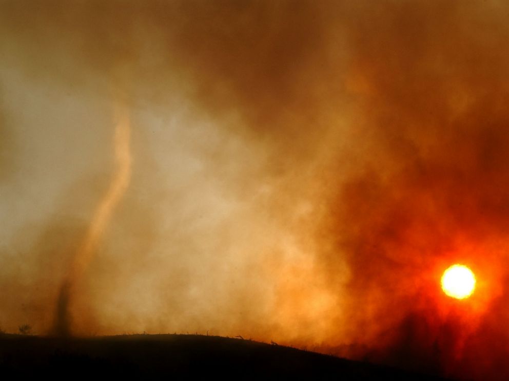 PHOTO: A wildfire-induced tornado of hot ash dances across a ridgetop as the sun sets May 13, 2002 near Rancho Santa Margarita, CA.