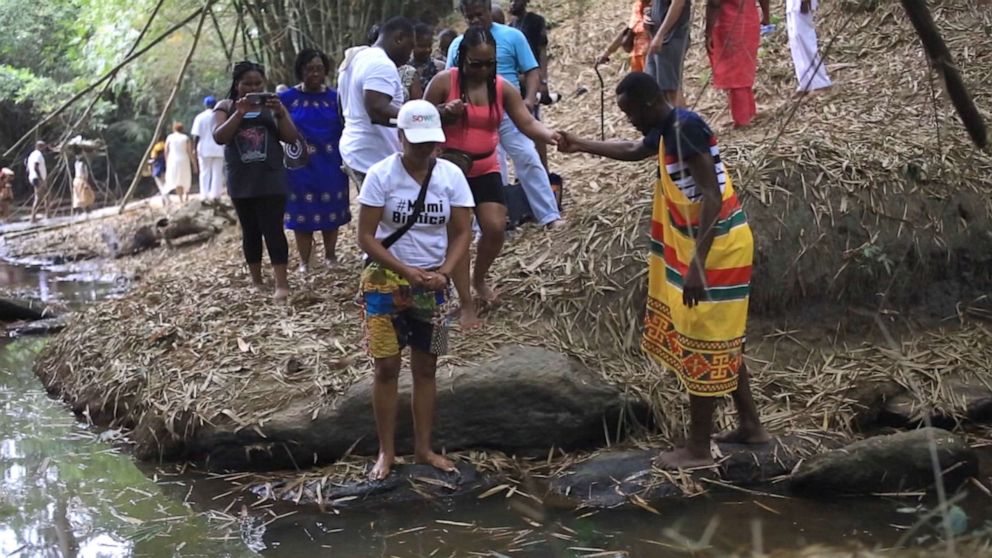 PHOTO: Tourists stand at the Assin Manso Slave River site, where soon-to-be enslaved Africans had their "last bath" on their native land.