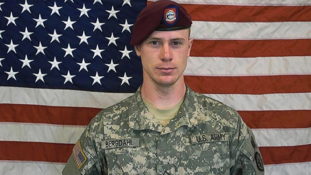 In this undated image provided by the U.S. Army, Sgt. Bowe Bergdahl poses in front of an American flag. 