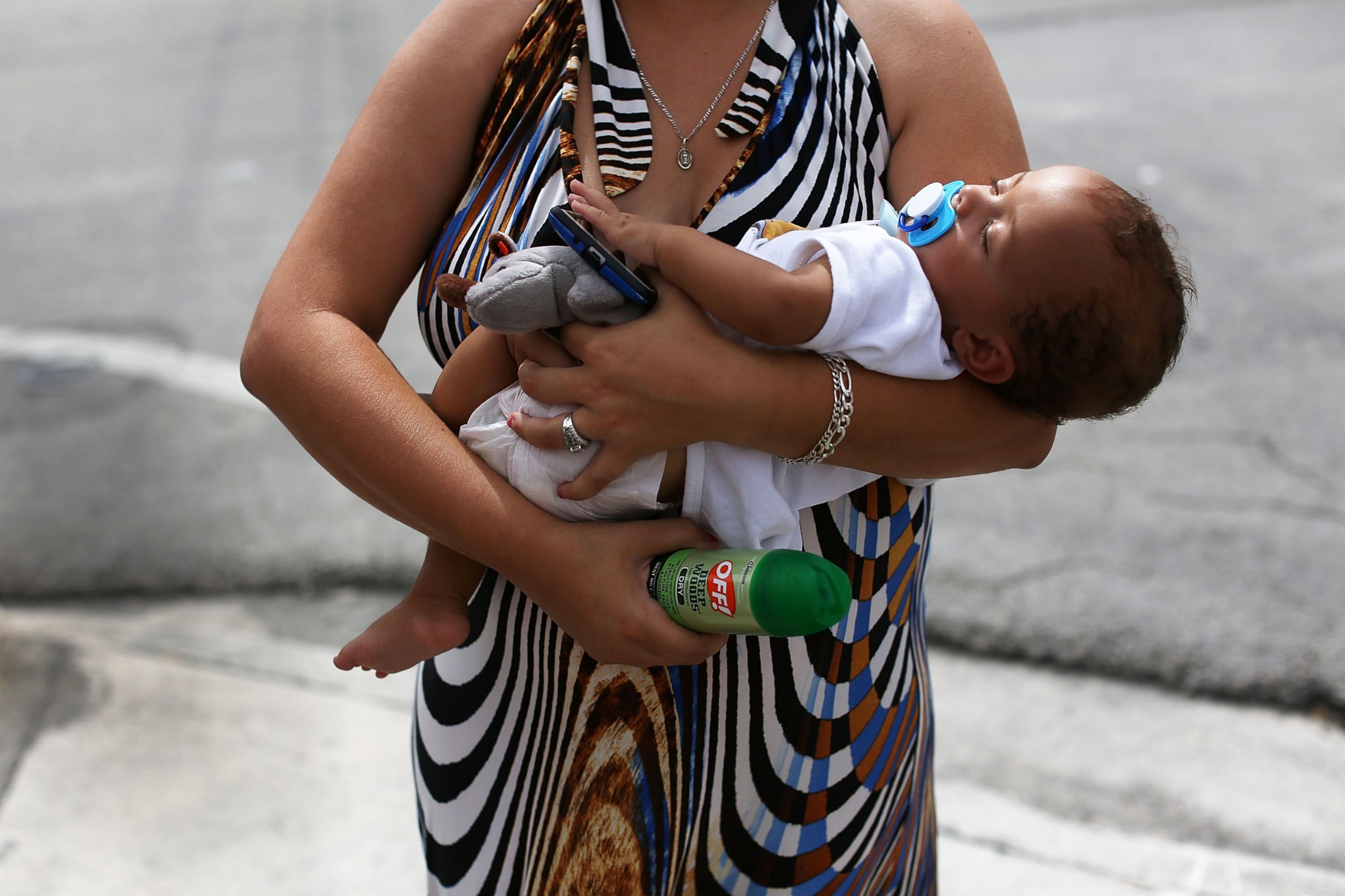 PHOTO: Barbara Betancourt holds her baby Daniel Valdes after being given a can of insect repellent by James Bernat, a City of Miami police officer