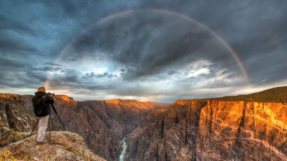 A rainbow arcs over Black Canyon as the sun rises at Gunnison National Park in Colorado.