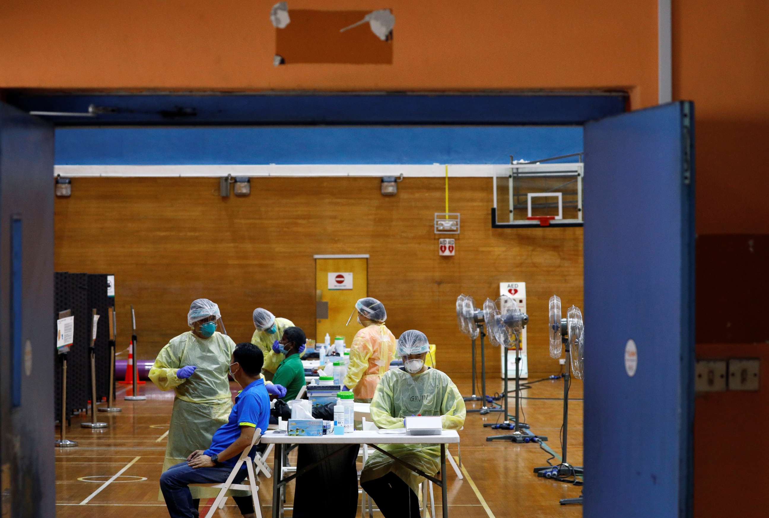 PHOTO: Essential workers have their noses swabbed before returning to the workforce at a regional screening center, amid the coronavirus disease (COVID-19) outbreak in Singapore June 10, 2020.   