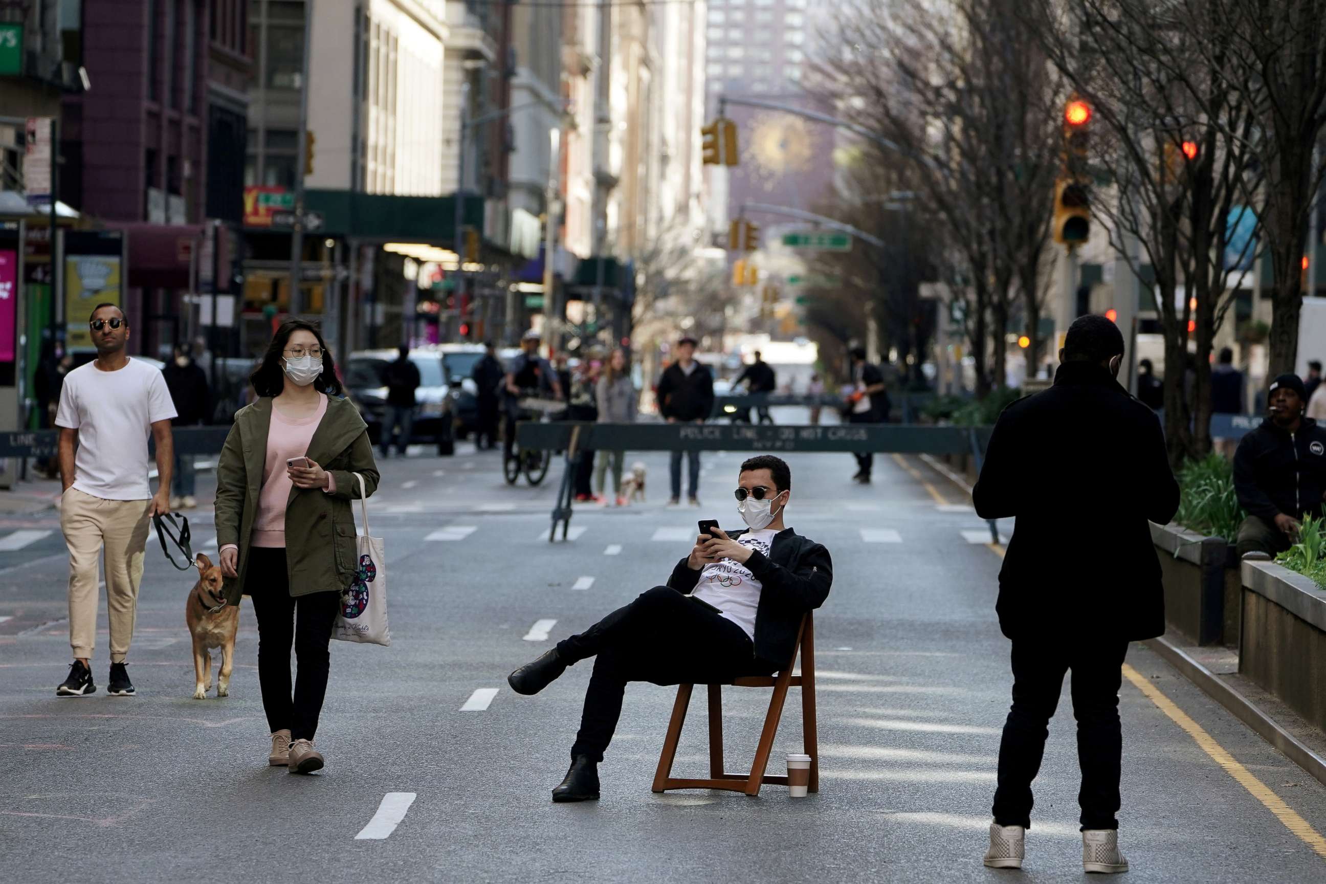 FILE PHOTO: A man sits on a chair as people walk on Park Avenue that was closed to vehicular traffic during the outbreak of coronavirus disease (COVID-19), in the Manhattan borough of New York City, New York, U.S., March 27, 2020. 