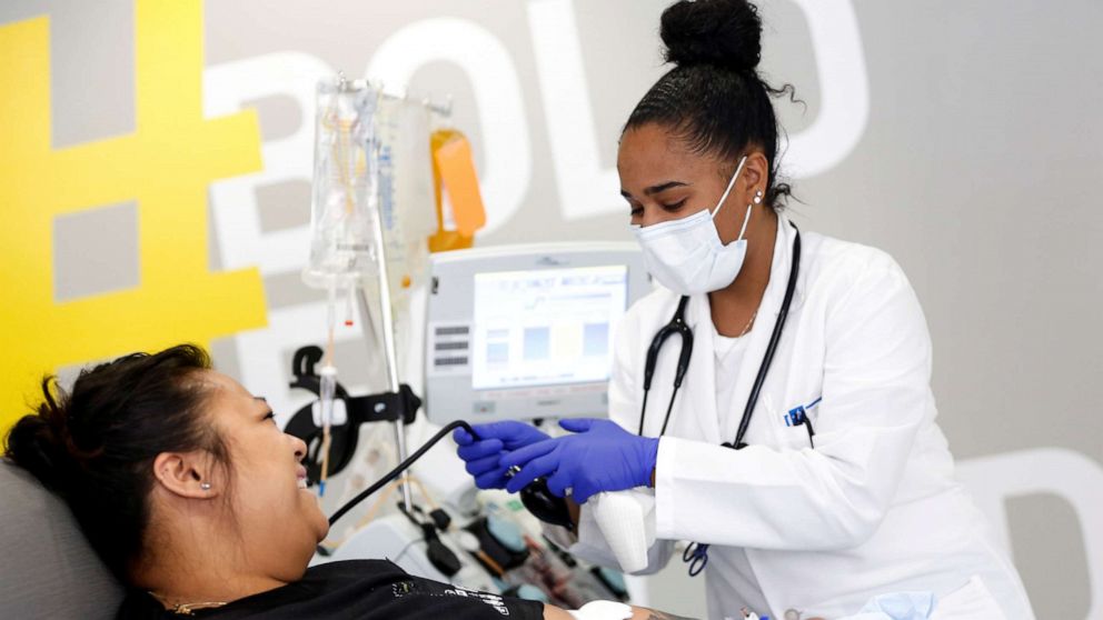 FILE PHOTO: Phlebotomist Jenee Wilson talks with Melissa Cruz, an ER technician for Valley Medical Center who has recovered from the coronavirus disease (COVID-19) she contracted from a patient in Seattle, Washington, U.S. April 17, 2020.