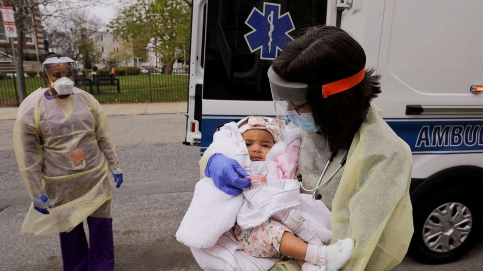PHOTO: Boston Medical Center pediatrician Dr. Sara Stulac holds five month-old Nairobi Kyra Osorio before Dr. Stulac and nurse Angelee Bullock perform a routine check-up in an ambulance in front of Osorio's home in Boston, Massachusetts, on May 8, 2020.