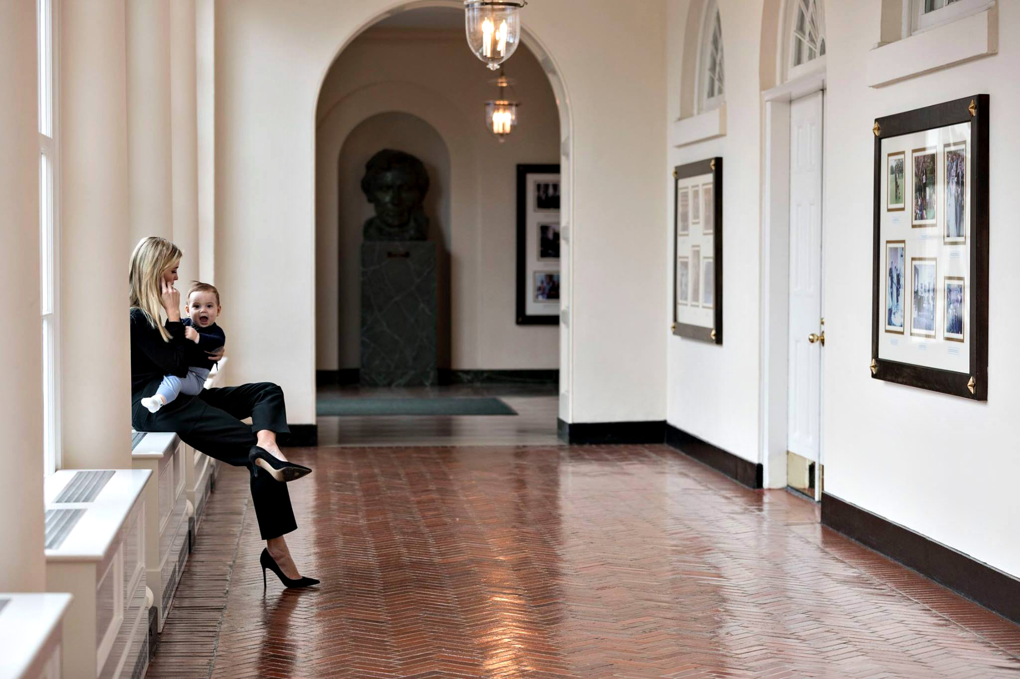 PHOTO: Holding her youngest son Theodore, Ivanka Trump talks on the phone in the East Colonnade of the White House, Jan. 29, 2017, in Washington.
