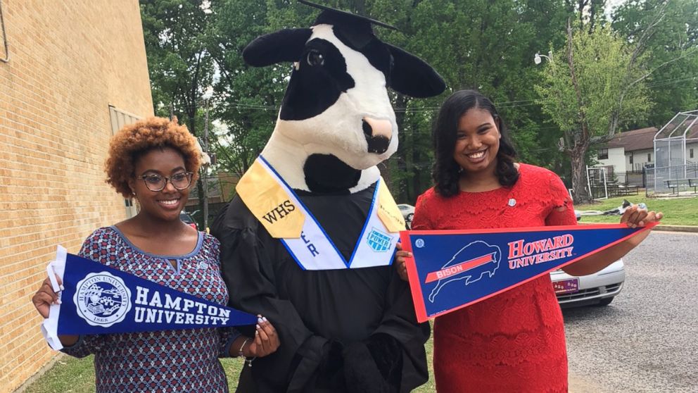 PHOTO: MacKenzie Walker, left, holds up her Hampton University banner, while her classmate, Cassietta Jones, right, holds up her Howard University banner. 