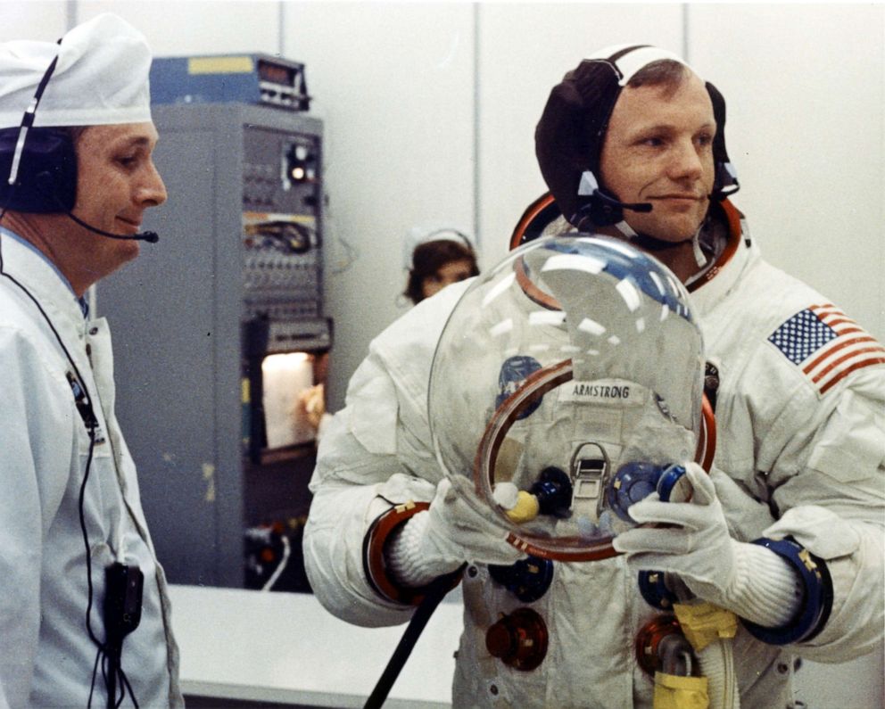 PHOTO: Apollo 11 Commander Neil Armstrong prepares to put on his helmet with the assistance of a spacesuit technician during suiting operations in the Manned Spacecraft Operations Building (MSOB) prior to the astronauts' departure to Launch Pad 39A.